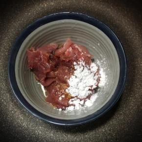 放入碗中加入酱油，玉米淀粉和1勺食用油，用手抓匀备用。