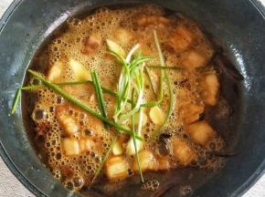 加入没过食材的啤酒，再加入剩余的白糖，生抽，老抽和葱姜蒜，大火烧开转中小火，盖上盖子焖煮20分钟