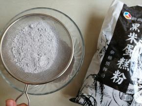 将黑米蛋糕粉先过筛一下，过筛后你会发现，筛网里面会有一点点还没完全磨成粉末的黑米和黑芝麻的颗粒。这些颗粒可别倒了，那可是营养，直接撒入过筛后的面粉里