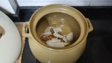汤煲里先放入小量水煮开后放入火龙果花干和响螺片块继续中小火煲