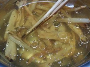 继续处理浸泡好的沙虫干：在盆里放入油和料酒（有助沙虫干更方便吐出沙子）