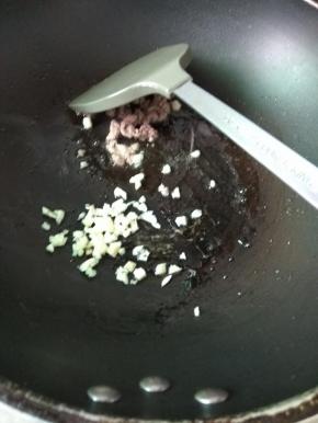 肉沫变色后加入蒜末，炒香
