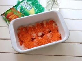 将处理好的鸡翅平铺在容器内；撒入35gcook腌料，加入30g清水，并给鸡翅们做个spa按摩~使鸡翅更加入味；盖上保鲜膜放入冰箱冷藏腌制50分钟以上；