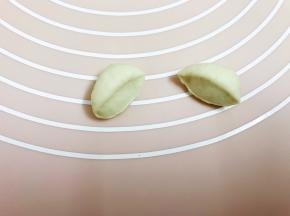 取15克重面团滚圆一切为二，用刮板从中间压扁