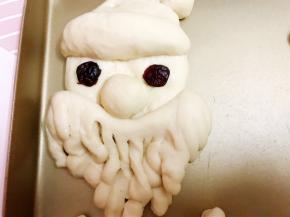 摆在脸部下面位置，剩余的两个小面团摆在脸部中间，用蔓越莓干当做眼睛
放入不通电的烤箱中层二发至2倍大
同时放入一碗热水保持湿度和温度