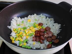 加入炒好的黑椒牛肉肠、青豆粒、玉米粒，一起大火翻炒，炒至米饭粒粒分明。