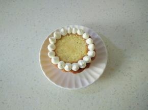 淡奶油加糖打发装入裱花袋，把蛋糕表面鼓起部分切掉，在蛋糕四周挤一圈圆球。