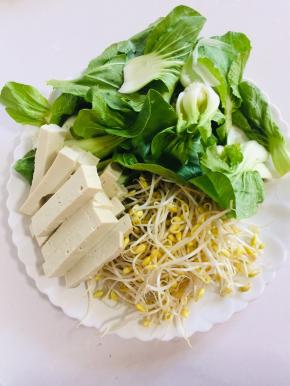 把配菜准备好：
小青菜清洗干净，黄豆芽清洗干净，豆腐打成条儿备用。