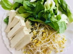 把配菜准备好：
小青菜清洗干净，黄豆芽清洗干净，豆腐打成条儿备用。