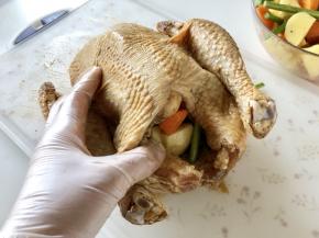 拿出腌制好的鸡，将炒过的蔬菜塞一部分在鸡腹中（塞了蔬菜会让鸡身看起来圆鼓鼓的，烤出来更漂亮）