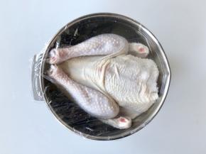 把鸡浸入盐水中，盐水没过鸡身，然后盖上保鲜膜，放入冰箱浸泡两个小时。