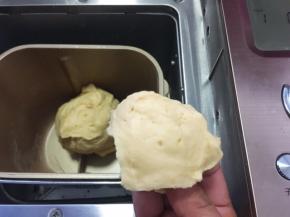 面包机启动揉面程序，将材料揉成面团，一个揉面程序为10分钟，揉好的面团切下一小块，横切面几乎没有孔洞即可
