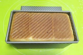 盖上吐司盒，入烤箱180度烤25分钟，出炉打开吐司盖子，将吐司倒出来降温，降至常温时，用锯齿刀将吐司切片
