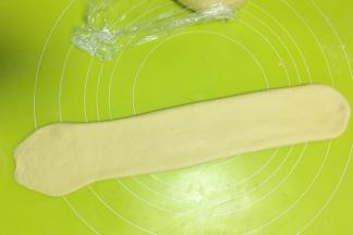 用擀面杖轻轻将面片擀宽一些，面片成厚度均匀即可，一侧的边缘擀的薄一些
