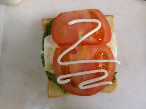 放上切片的番茄，再挤上适量沙拉酱，盖上另一块吐司片。