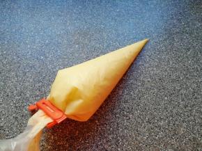 搅打好的蛋糕糊装进裱花袋，用夹子夹好口。