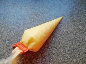 搅打好的蛋糕糊装进裱花袋，用夹子夹好口。