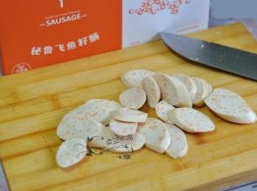 将飞鱼籽肠斜切成片。