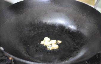 锅里倒入油，放入蒜粒炸香。
