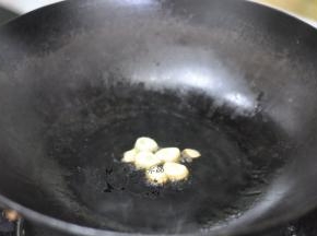 锅里倒入油，放入蒜粒炸香。