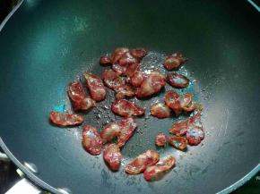 热锅，把腊肠煎至透明