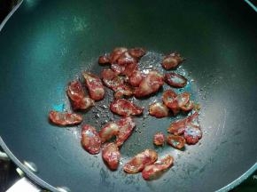 热锅，把腊肠煎至透明