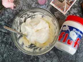 将打发好的淡奶油倒入奶油奶酪里混合均匀