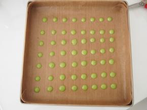 烤盘中铺上油布，将抹茶面糊装入裱花袋中，在油布上挤上波点，放入烤箱，160度中层上下火，烘烤1分钟定型后取出