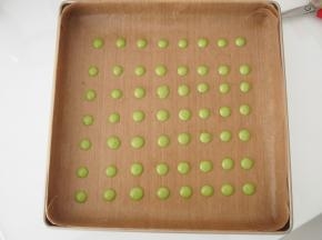 烤盘中铺上油布，将抹茶面糊装入裱花袋中，在油布上挤上波点，放入烤箱，160度中层上下火，烘烤1分钟定型后取出