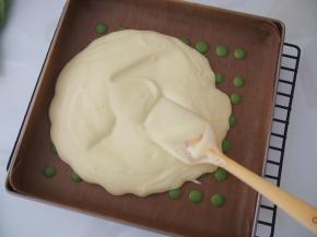 将原味面糊距离烤盘20厘米左右倒入；用刮刀将面糊铺平，震出大气泡