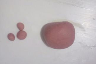 再取一个小面团，分出一个1克的小面团，把这个小面团按2:1:1分成三份搓圆，大点的捏成圆梯形