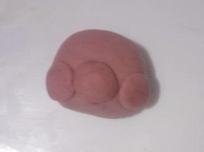 把三个小面团粘少量清水贴在大面团上如图，分别制作出小鹿的鼻子和脸蛋