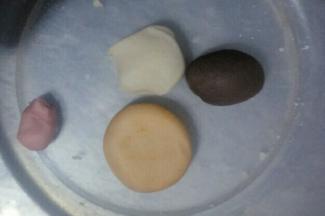 把白色面团分成4份，大小随意吧，总共30克面团(最后多出的可以制作成别的)，其中三块分别与粉色食用色粉，橙色食用色粉，奥利奥饼干碎末混合揉搓均匀