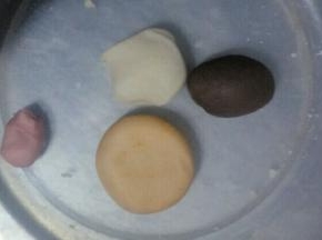 把白色面团分成4份，大小随意吧，总共30克面团(最后多出的可以制作成别的)，其中三块分别与粉色食用色粉，橙色食用色粉，奥利奥饼干碎末混合揉搓均匀