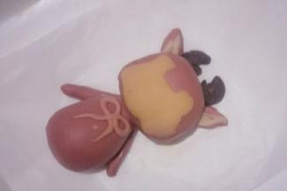 把制作好的面团分别粘少量的清水贴在小鹿的头部和身体部相应的位置