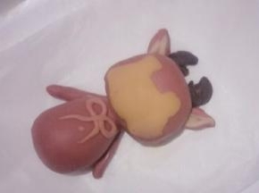 把制作好的面团分别粘少量的清水贴在小鹿的头部和身体部相应的位置