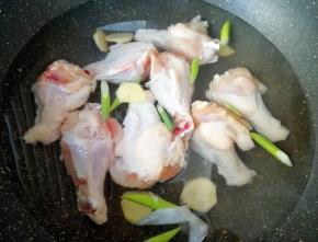 鸡翅根洗干净凉水入锅，放葱和姜，加入一勺料酒烧开焯水，焯好以后用凉水冲洗干净备用。