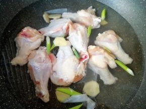 鸡翅根洗干净凉水入锅，放葱和姜，加入一勺料酒烧开焯水，焯好以后用凉水冲洗干净备用。