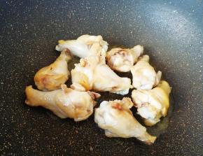 炒锅内倒适量的食用油烧热，下入鸡翅根煸炒至表皮微微焦黄。