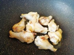 炒锅内倒适量的食用油烧热，下入鸡翅根煸炒至表皮微微焦黄。