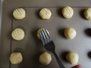 捏紧收口，搓圆。用叉子向下压一下，压扁一下面团，并在上面留有叉印
