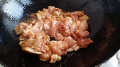 将腌好的鸡腿肉放入煸炒岀水分。