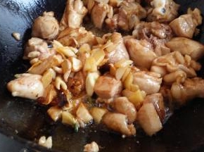 煸炒好鸡腿肉这时放入刚捞出的姜蒜粒继续煸炒，淋入米酒、加蚝油、生抽、老抽和适量高汤炖10分钟左右。