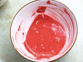 .接着把蛋糕糊平均分成两份。一份加入红丝绒液，搅拌均匀。