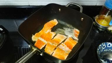 不粘锅热油，放入腌好的三文鱼骨