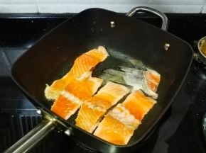 不粘锅热油，放入腌好的三文鱼骨