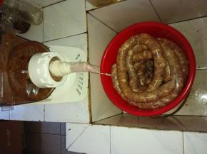 启动面条机，匀速将猪肉灌入肠衣中。