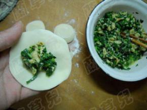 取一份擀成圆片，放入茼蒿鸡蛋馅。