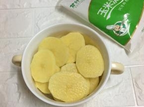 土豆去皮洗净，切成薄皮，放入碗中。