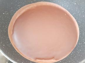 把阳晨24CM不粘锅放在燃气灶上开小火，取一勺面糊放在锅里。端起锅摇晃一圈使面糊均匀地平铺在锅底。